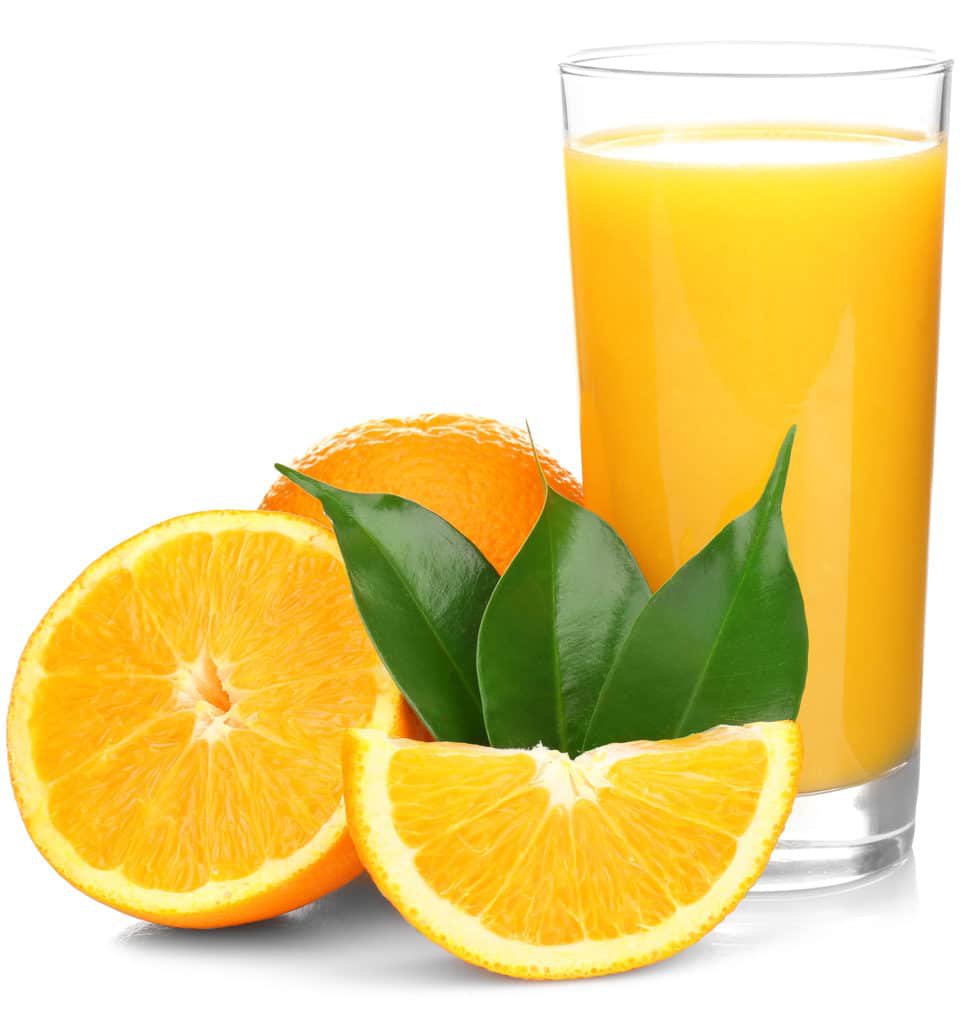 Orange juice in a cup and oranges